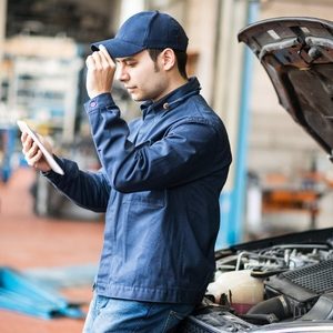 portrait of a mechanic using a tablet in his garage