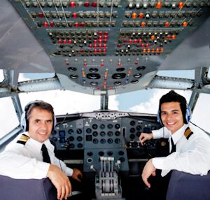cockpit with two pilots smiling at the camera