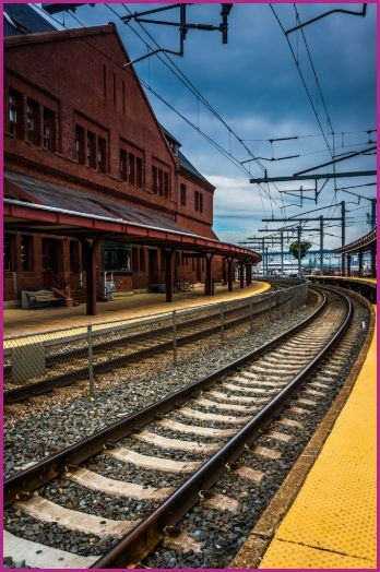 A railroad track curving around a red brick train depot