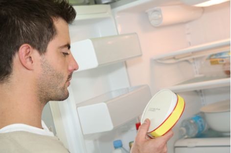 Guy looking at a wheel of cheese