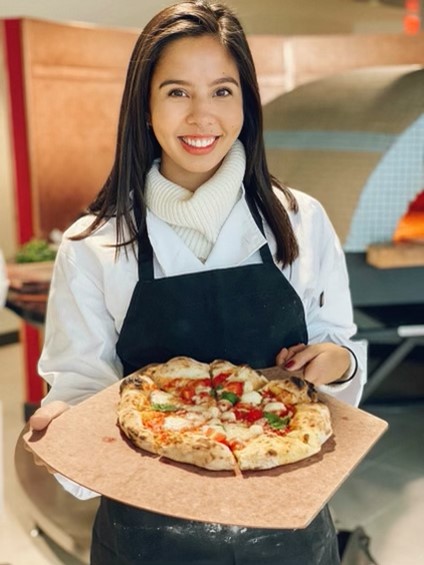 Young woman presenting a fresh pizza