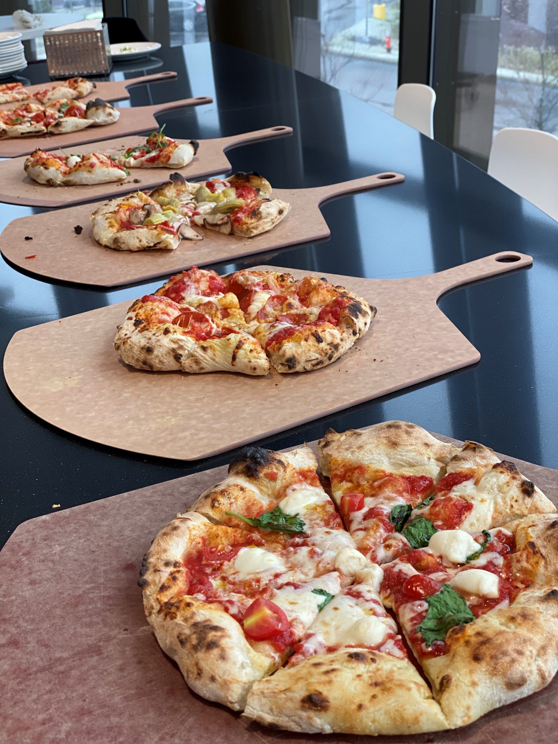 A row of fresh baked pizzas