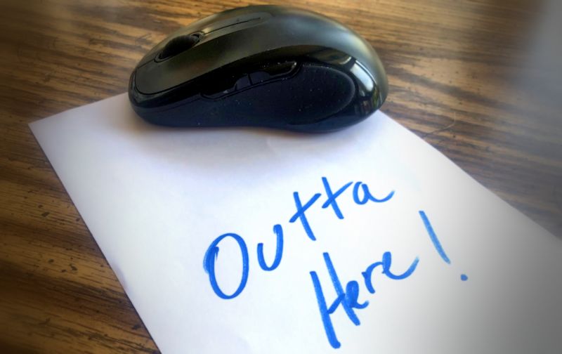 Computer mouse on a note that says outta here